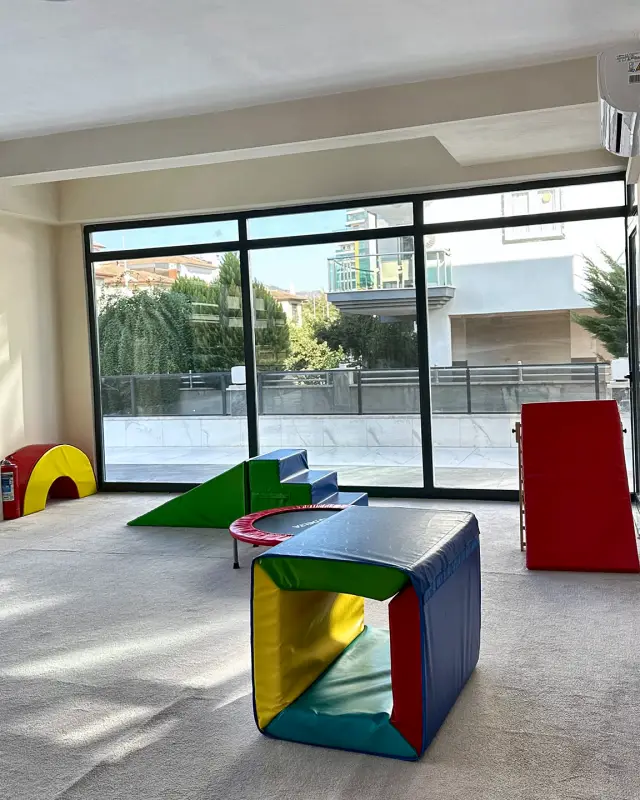 Yumuşak oyun blokları, kaydırak ve trambolin olan hareket alanı