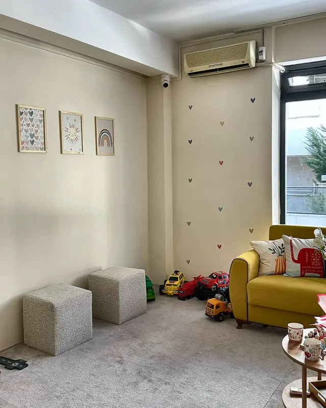 Sarı kanepe ve puflarla oturma köşesi